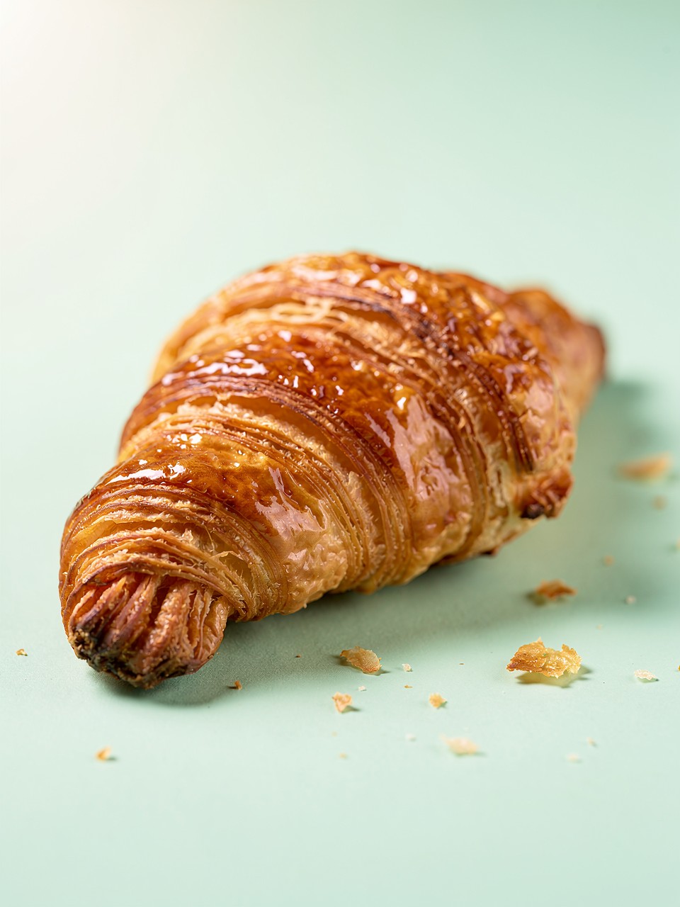 Croissant Dourado e Flaky em Fundo Verde Claro