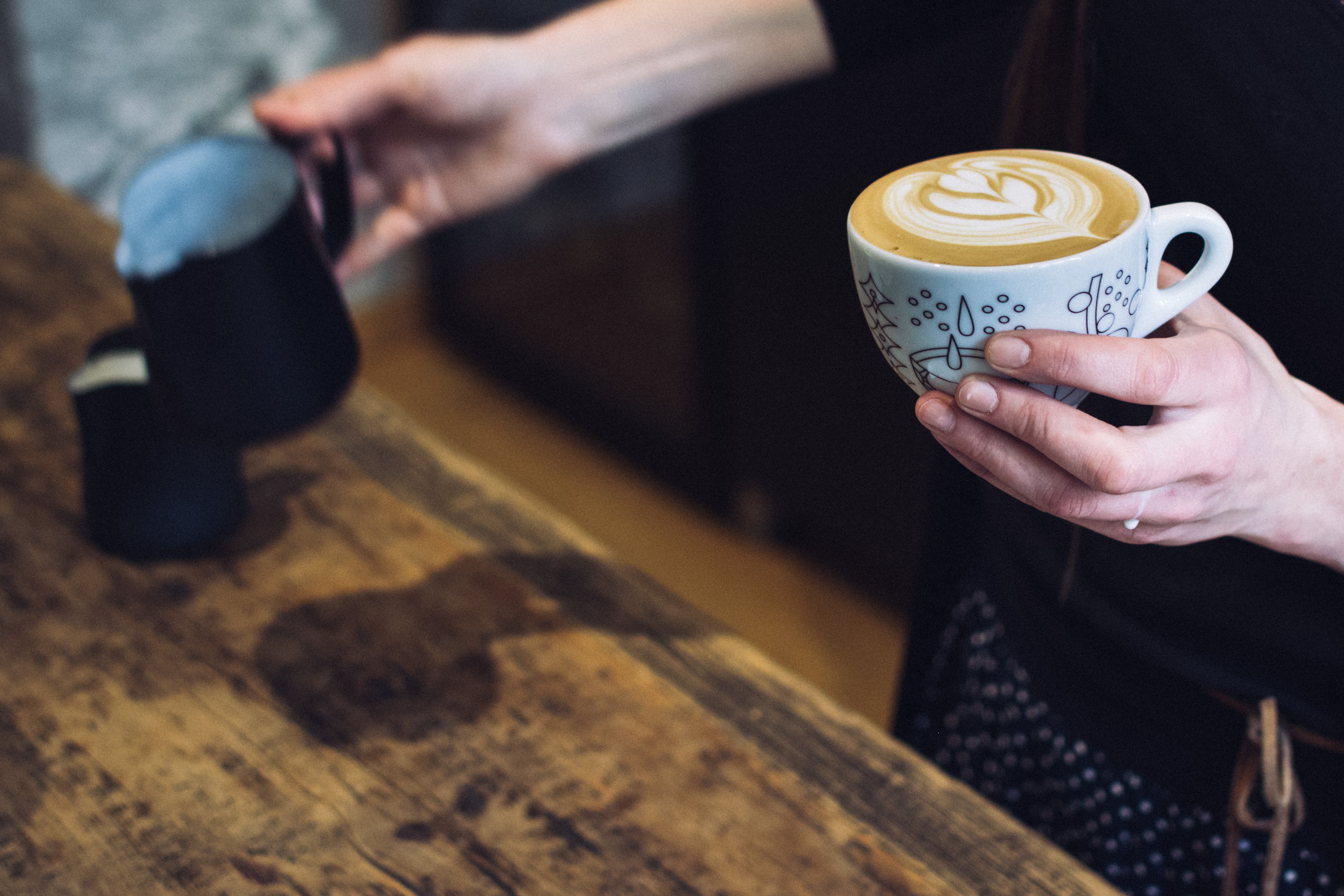 Barista holding a cup with coffee cappuccino