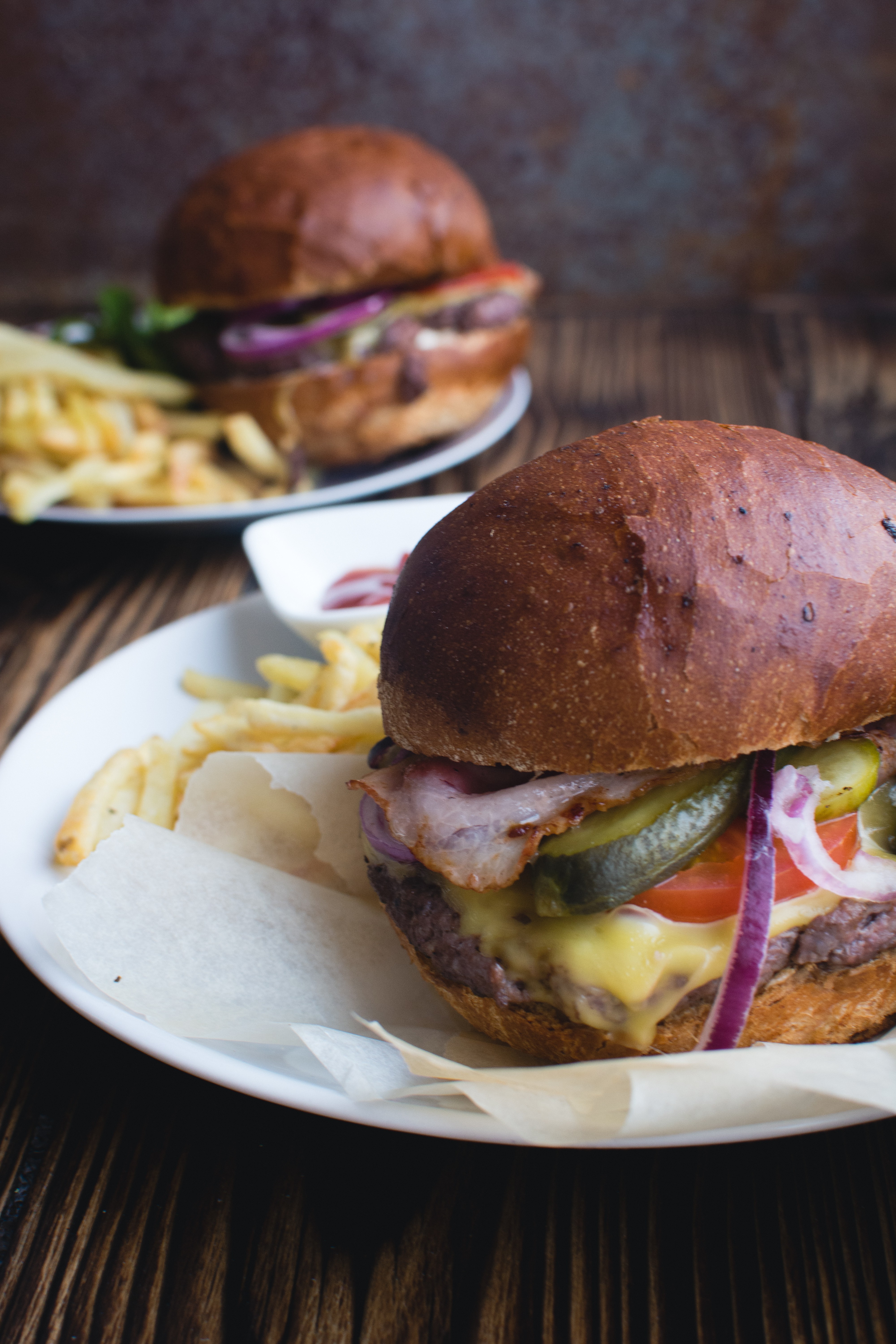 Hamburguesa con queso cheddar, tocino y papas fritas
