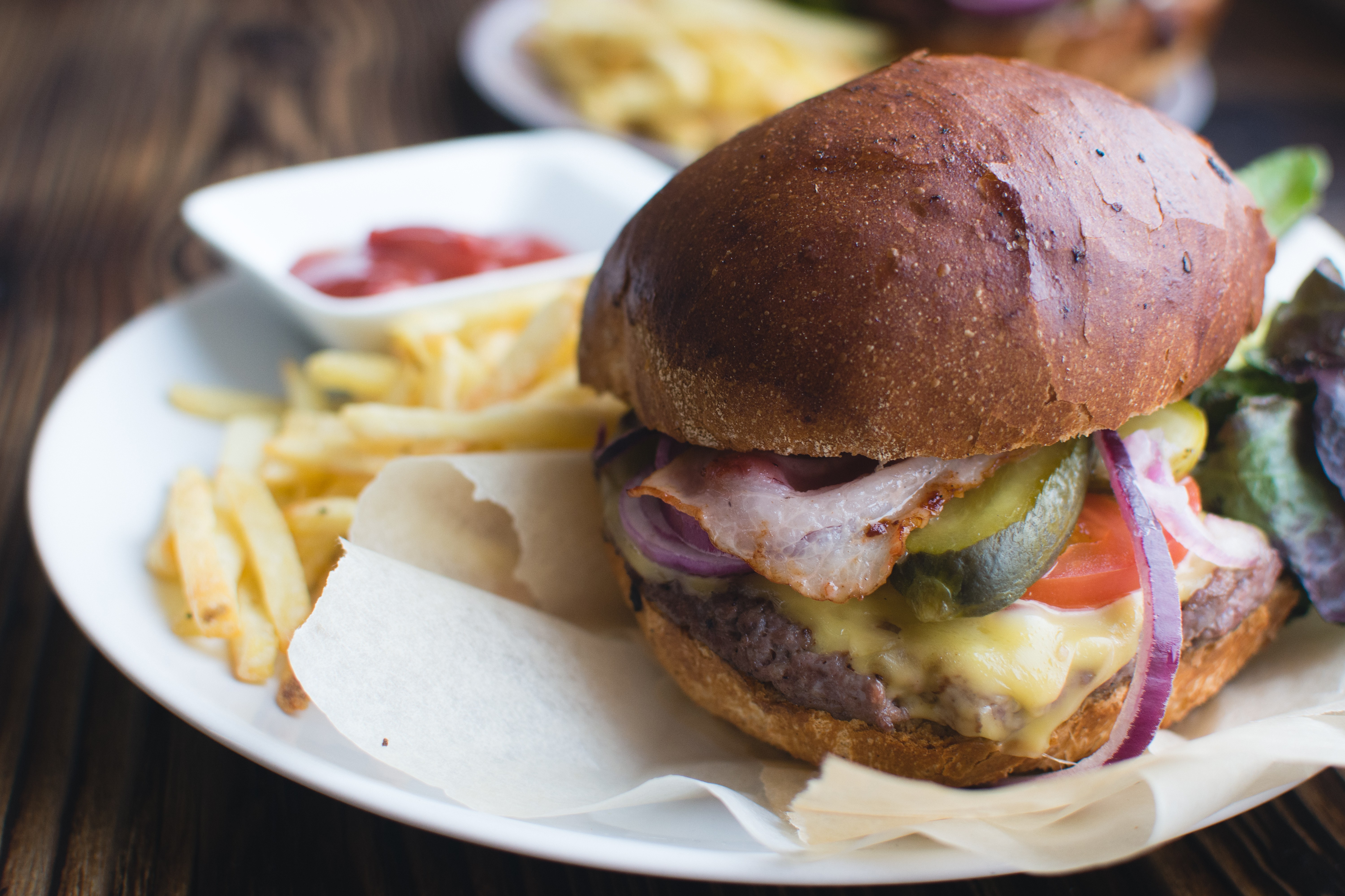 Hamburguesa con queso cheddar, tocino y papas fritas