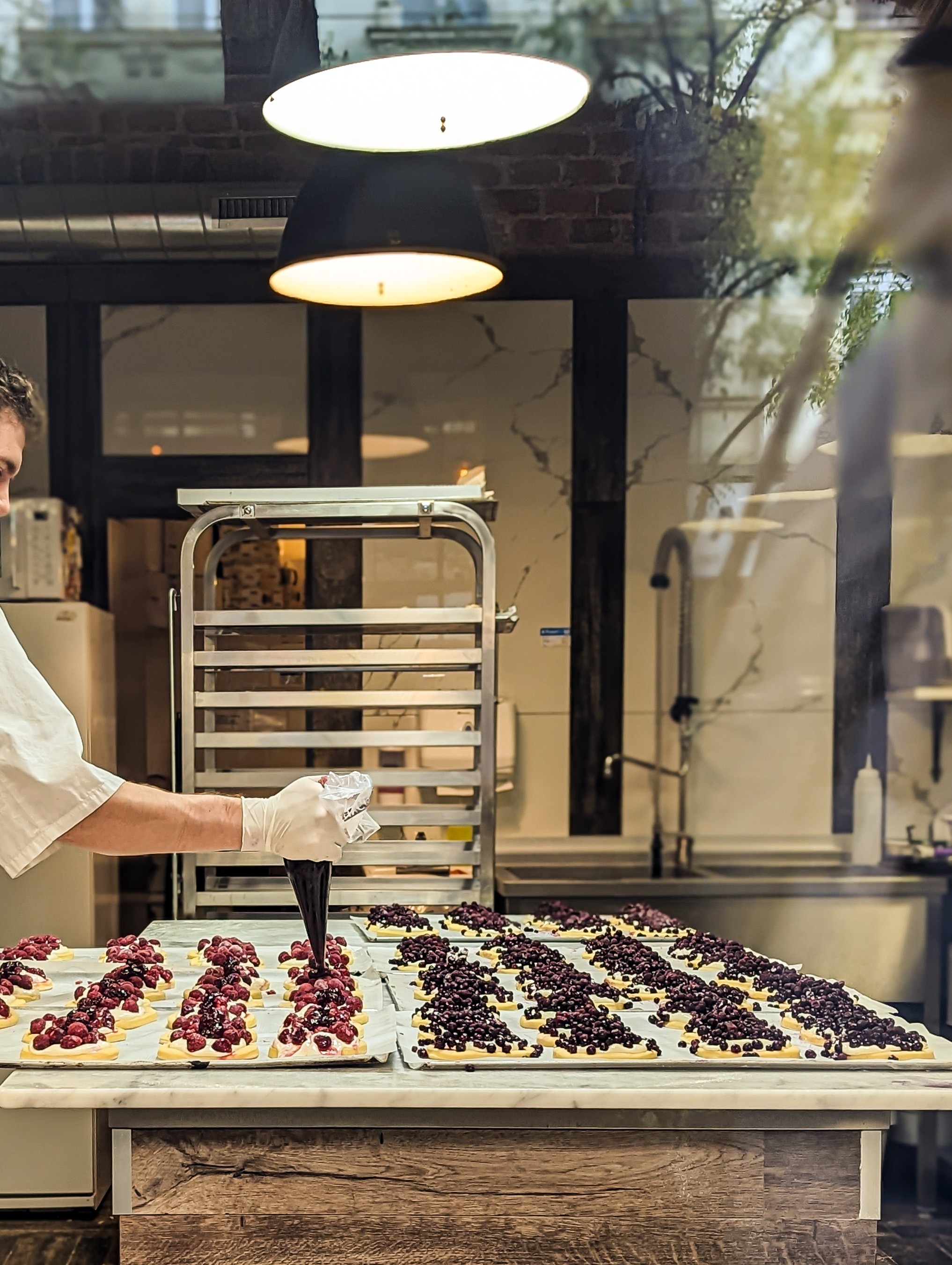Chef recheando tortas de frutas vermelhas antes de assar