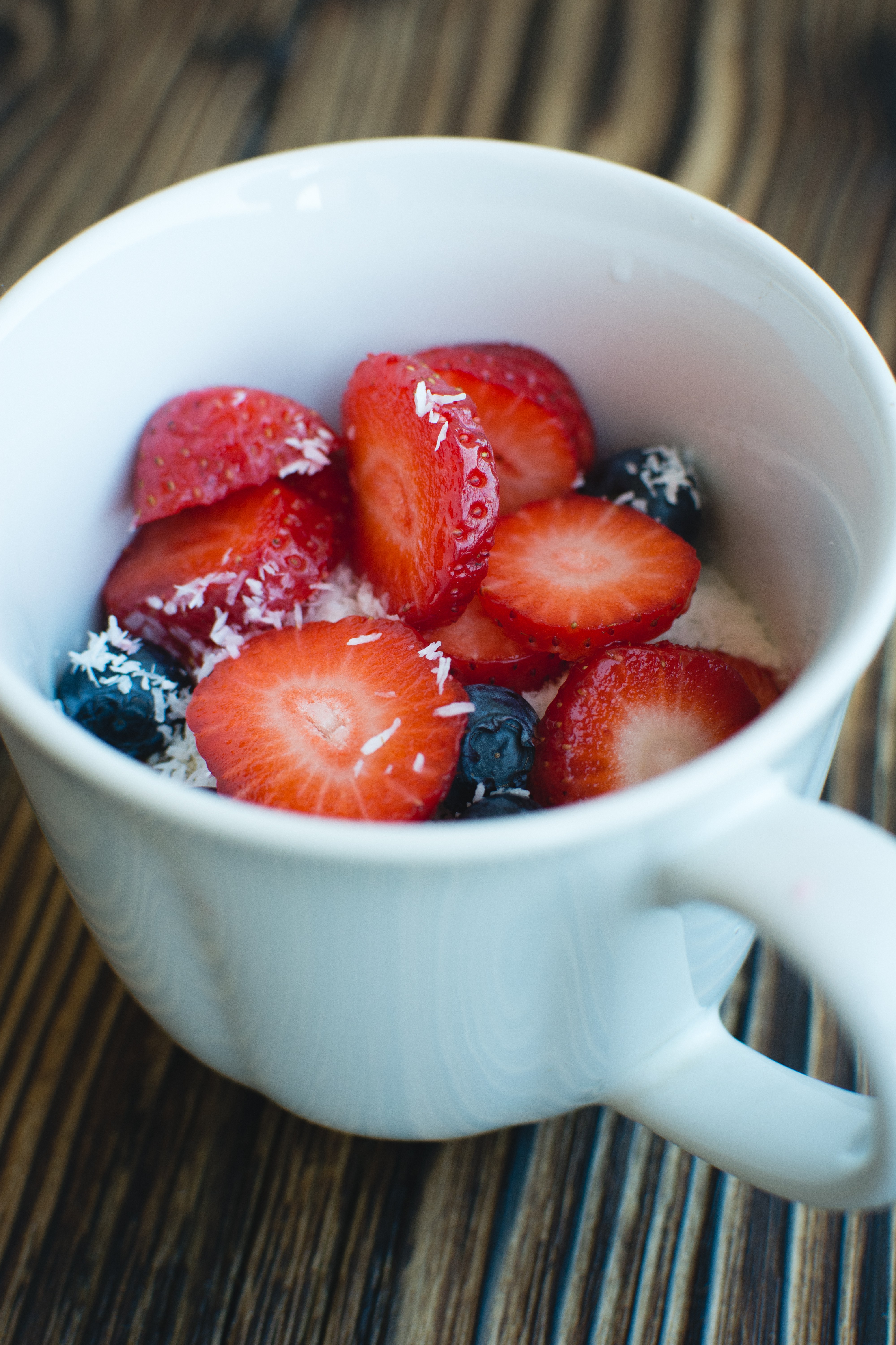 Cup of oatmeal with berries and coconut
