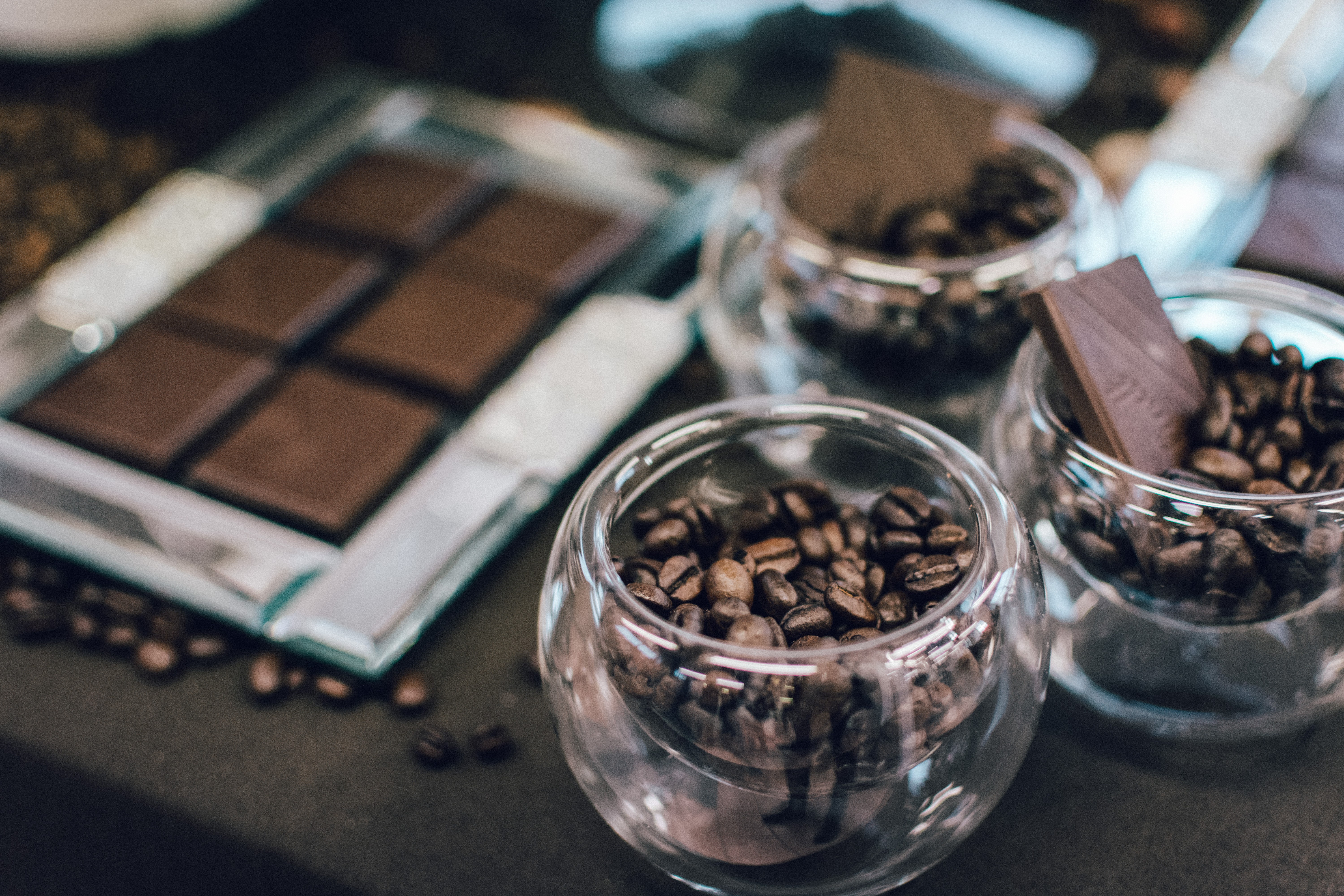 Barra de chocolate negro y granos de café en vasos