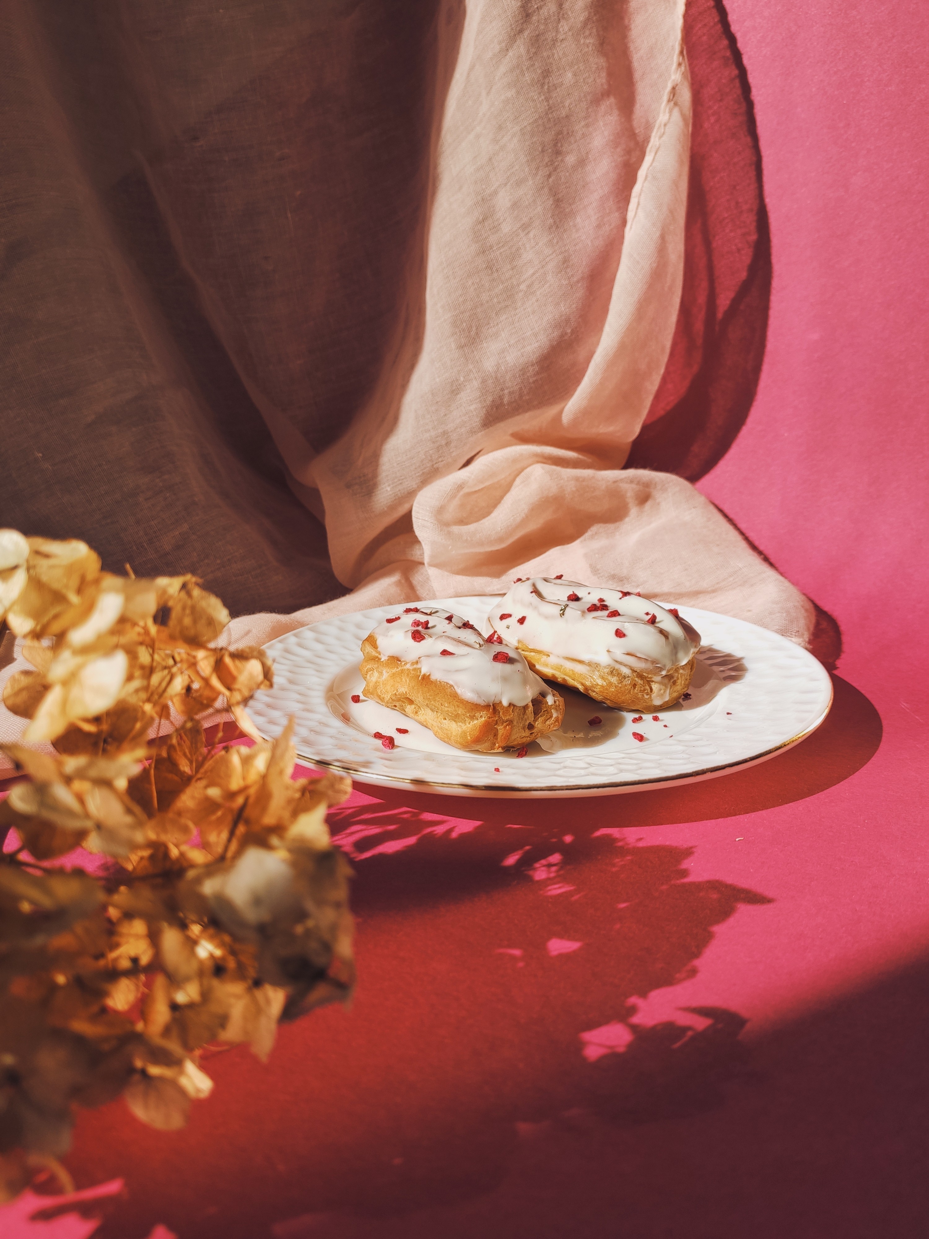 Eclairs deliciosos com cobertura branca e farofa de framboesa