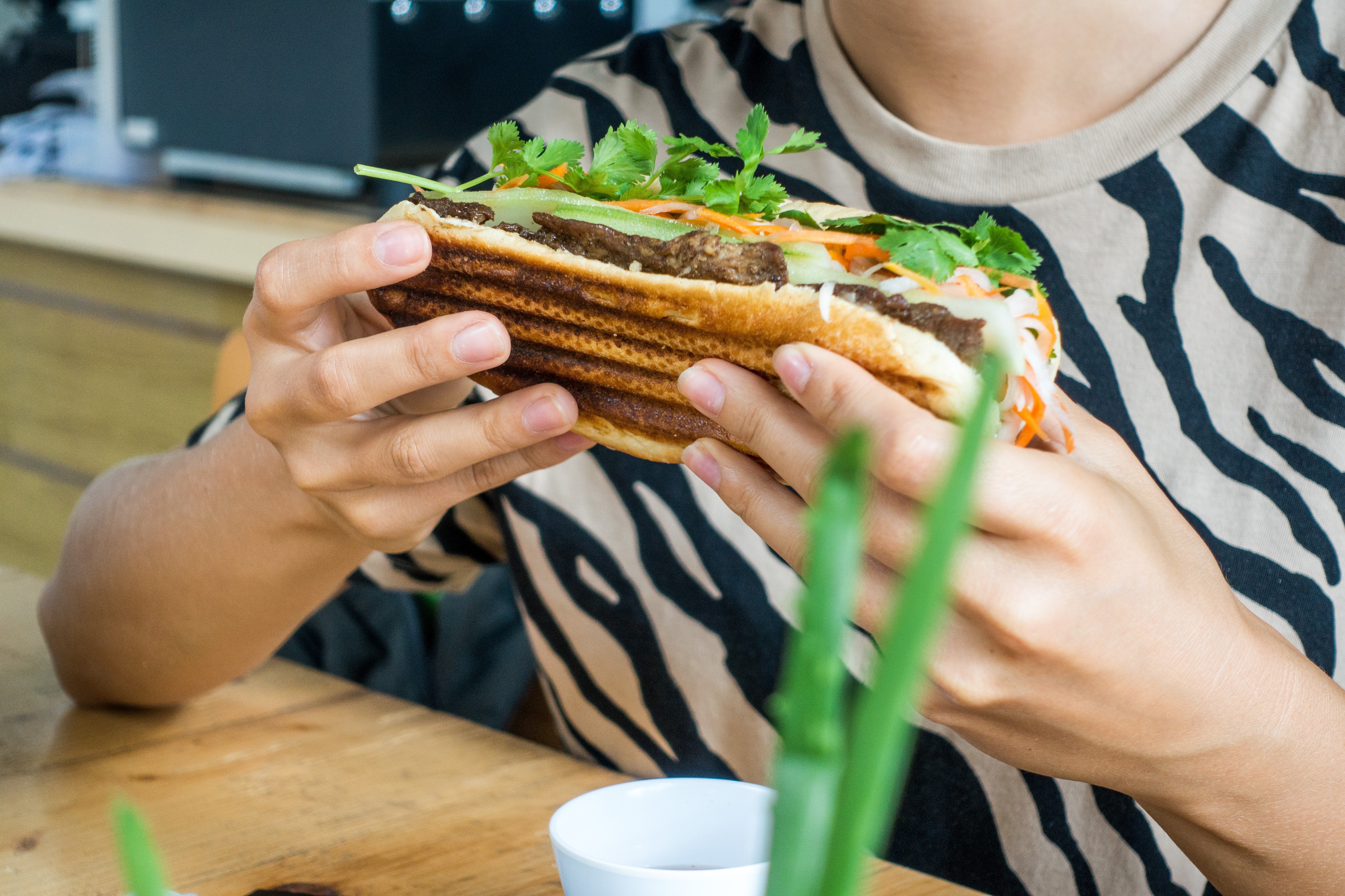 Menina comendo um fresco banh mi vietnamita