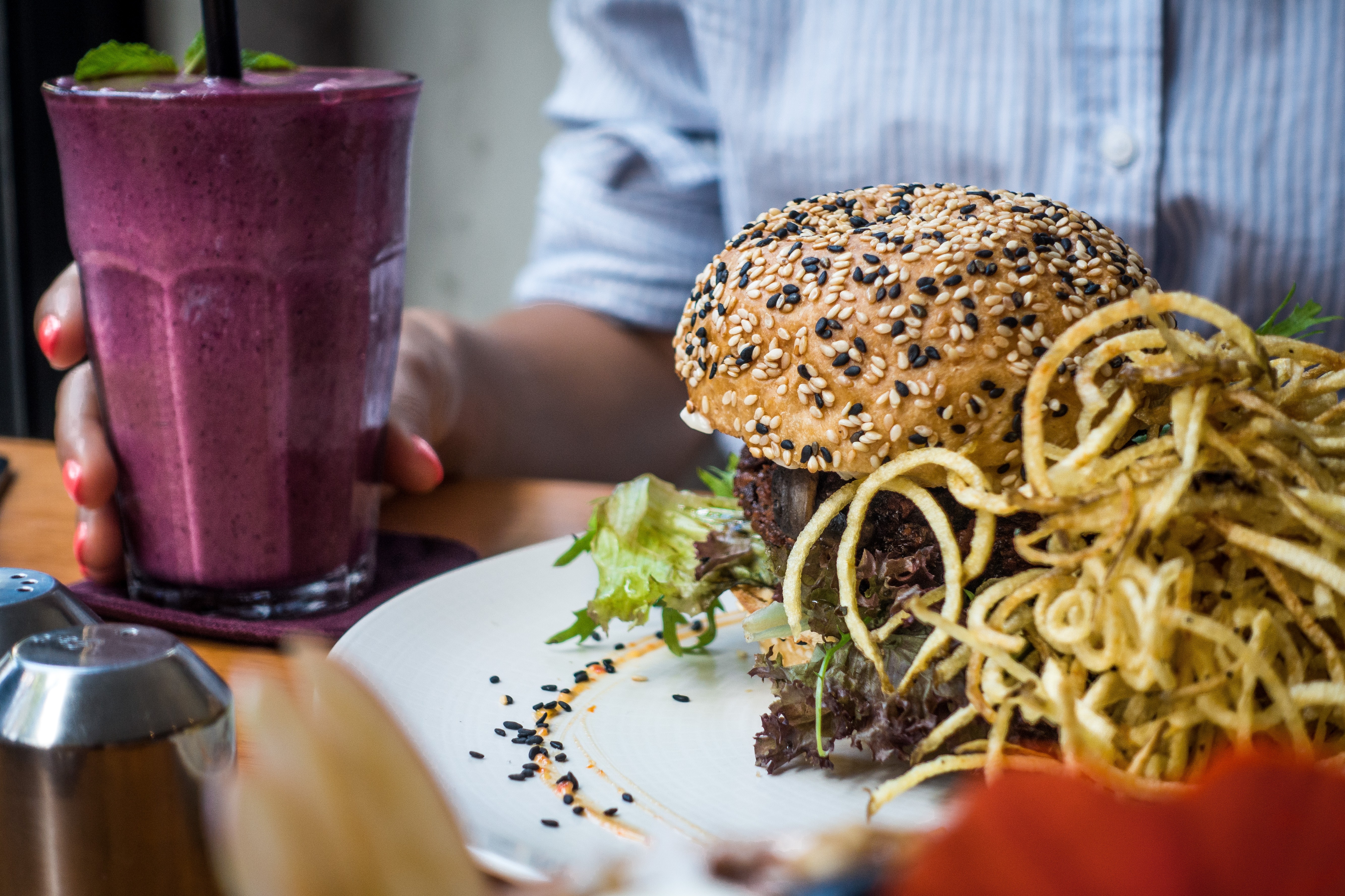 Girl having a vegan burger and smoothie