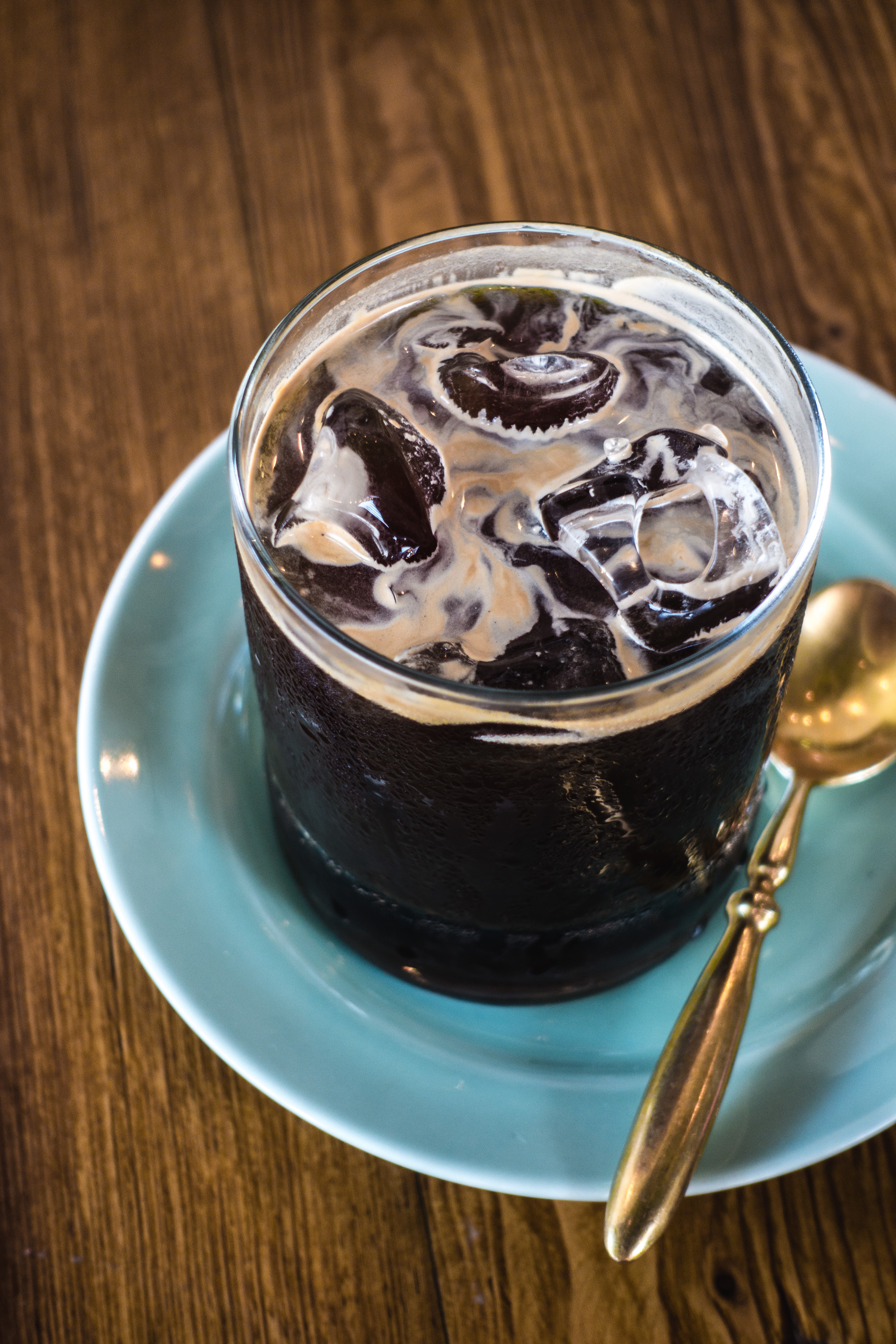Iced black coffee with golden spoon