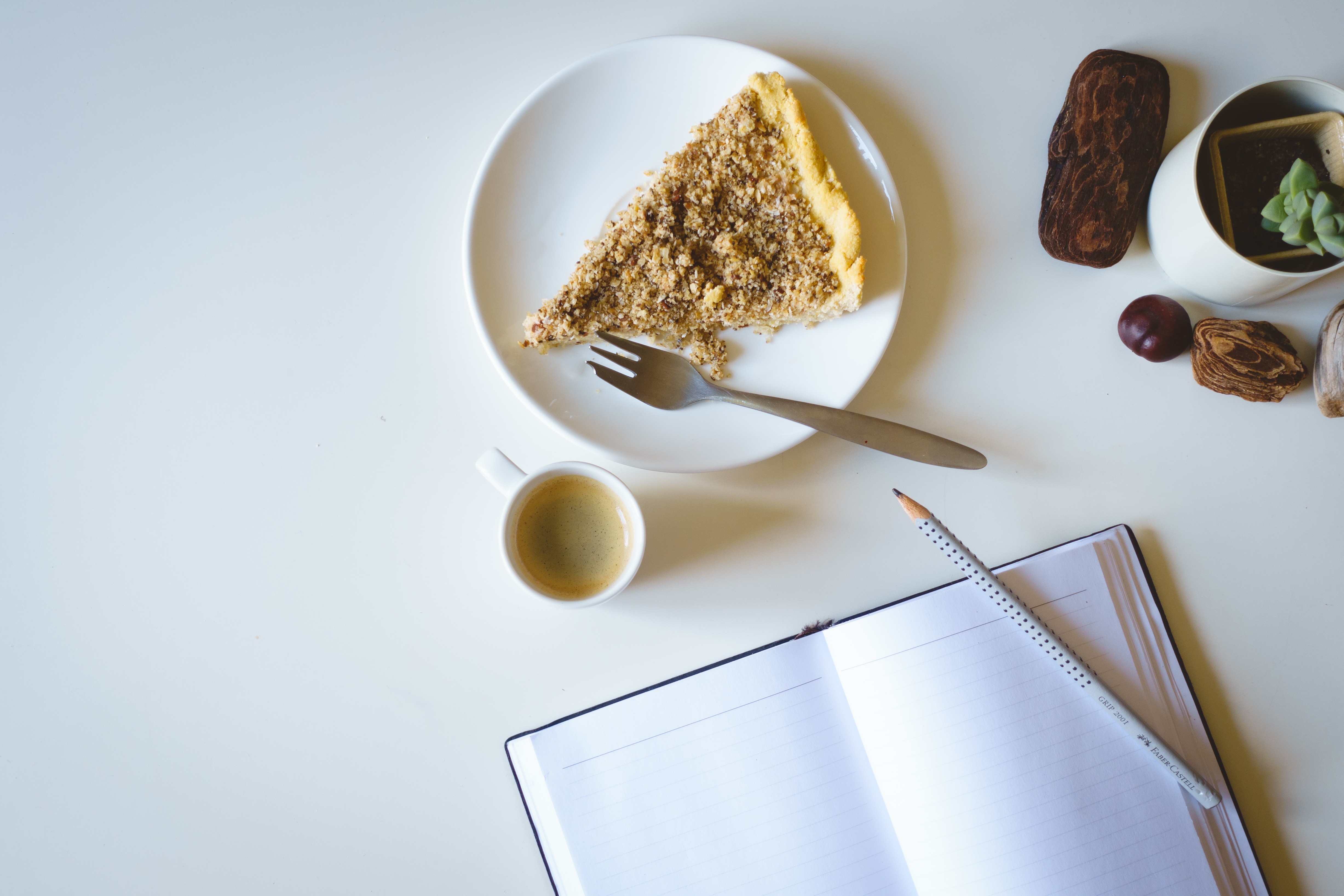 Escribiendo en un diario con pastel y café