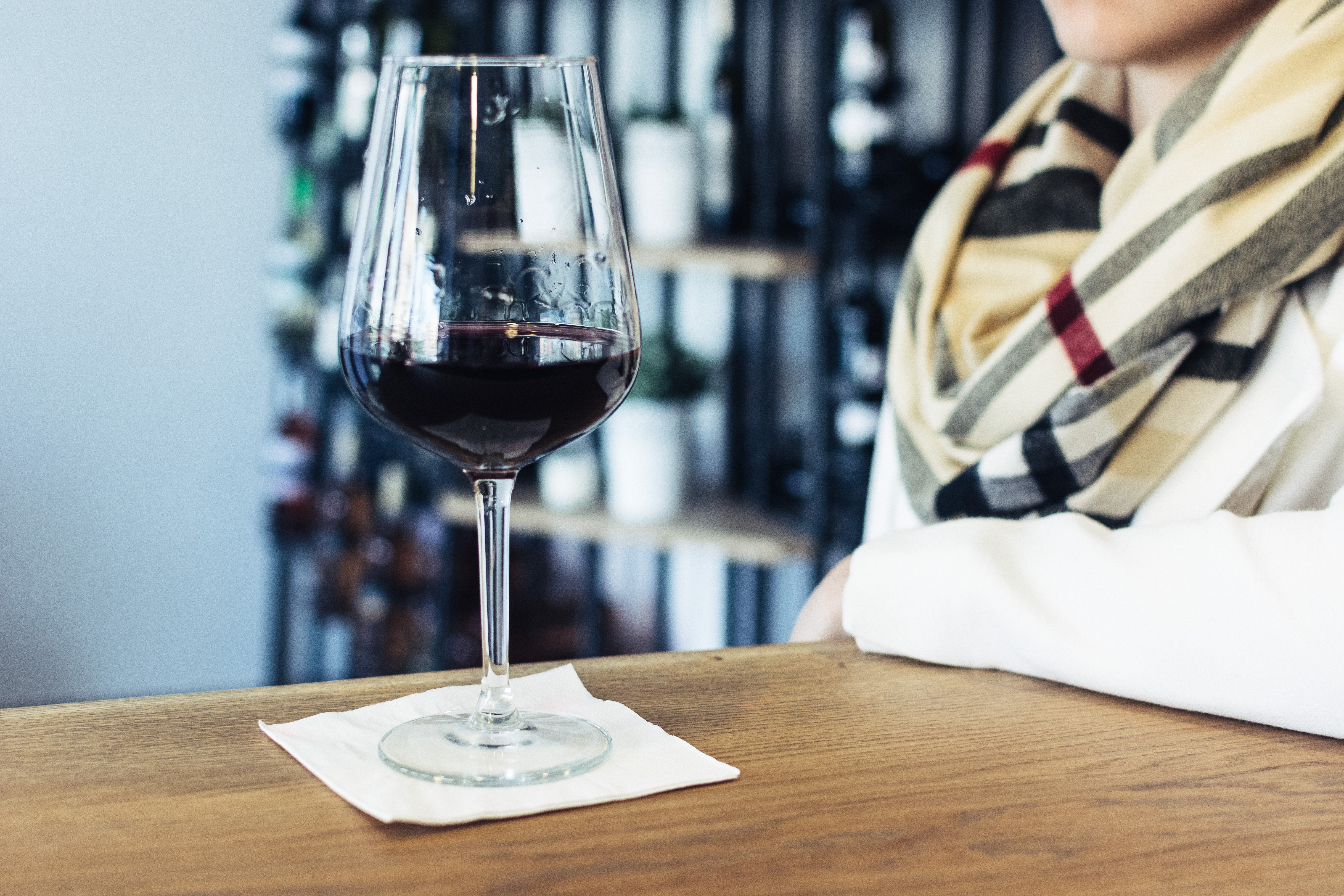 Mujer bebiendo su copa de vino tinto en una tienda de vinos