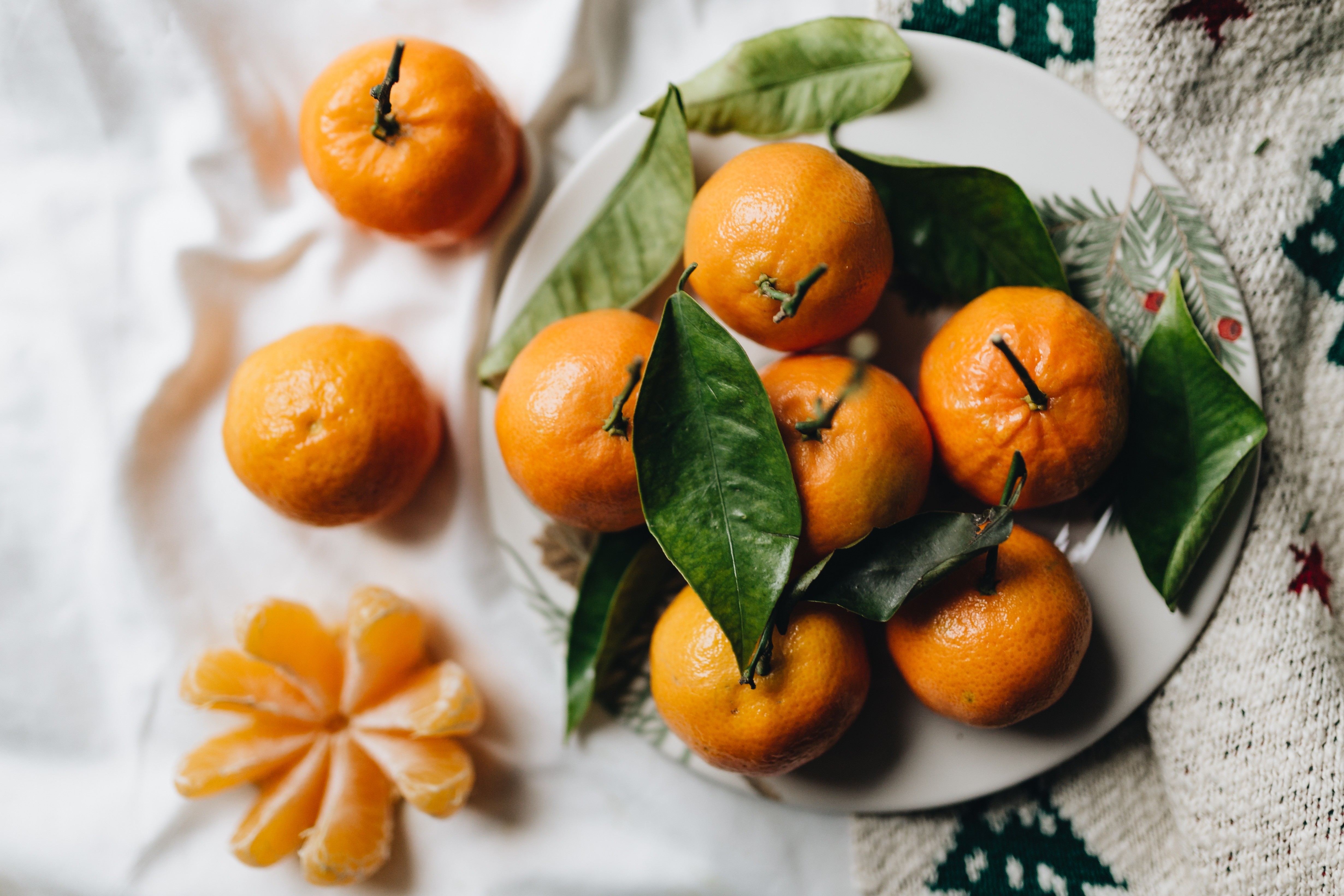 Tangerines with leaves on a white linen