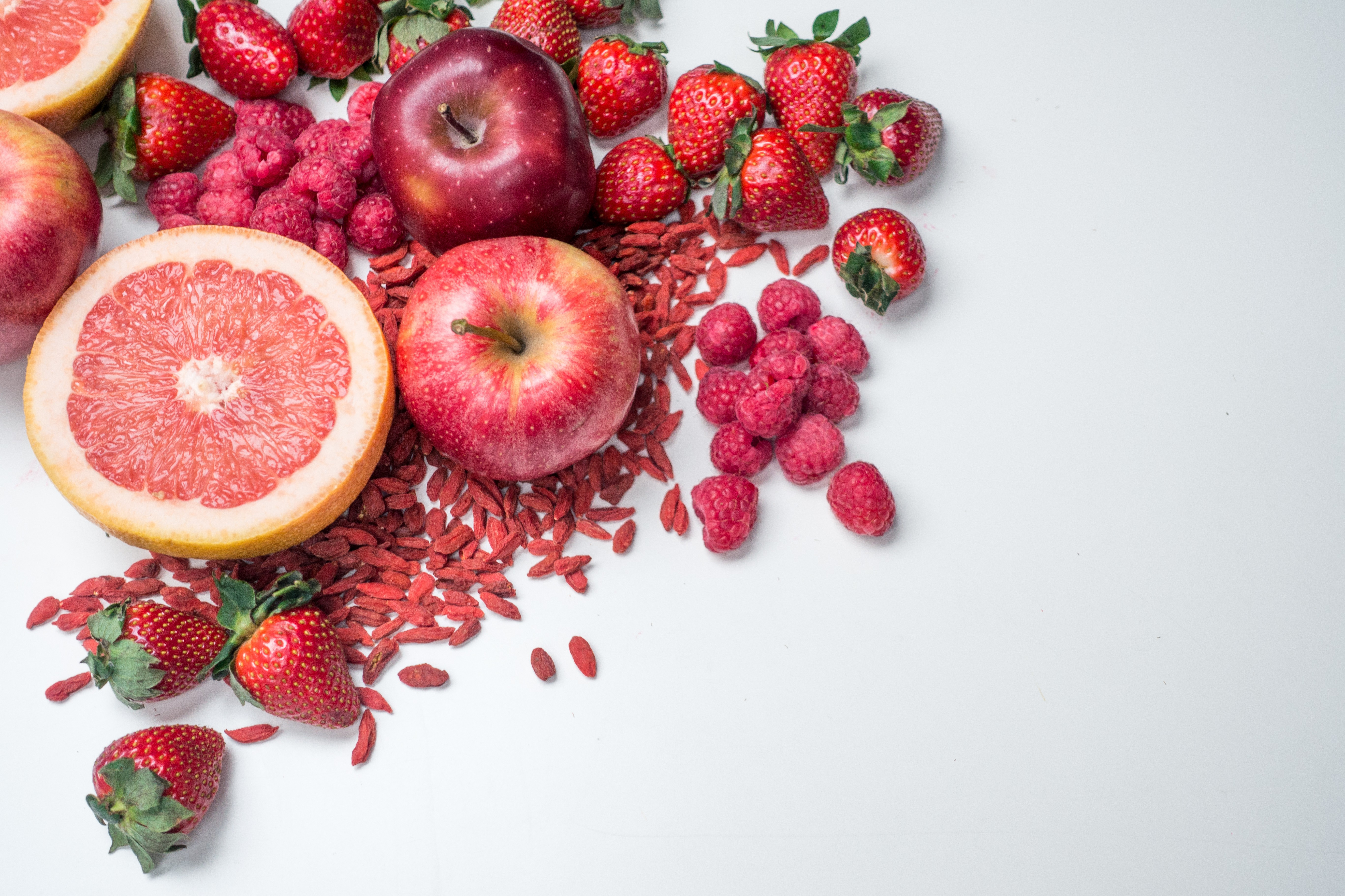 Frutas e vegetais vermelhos sobre fundo branco