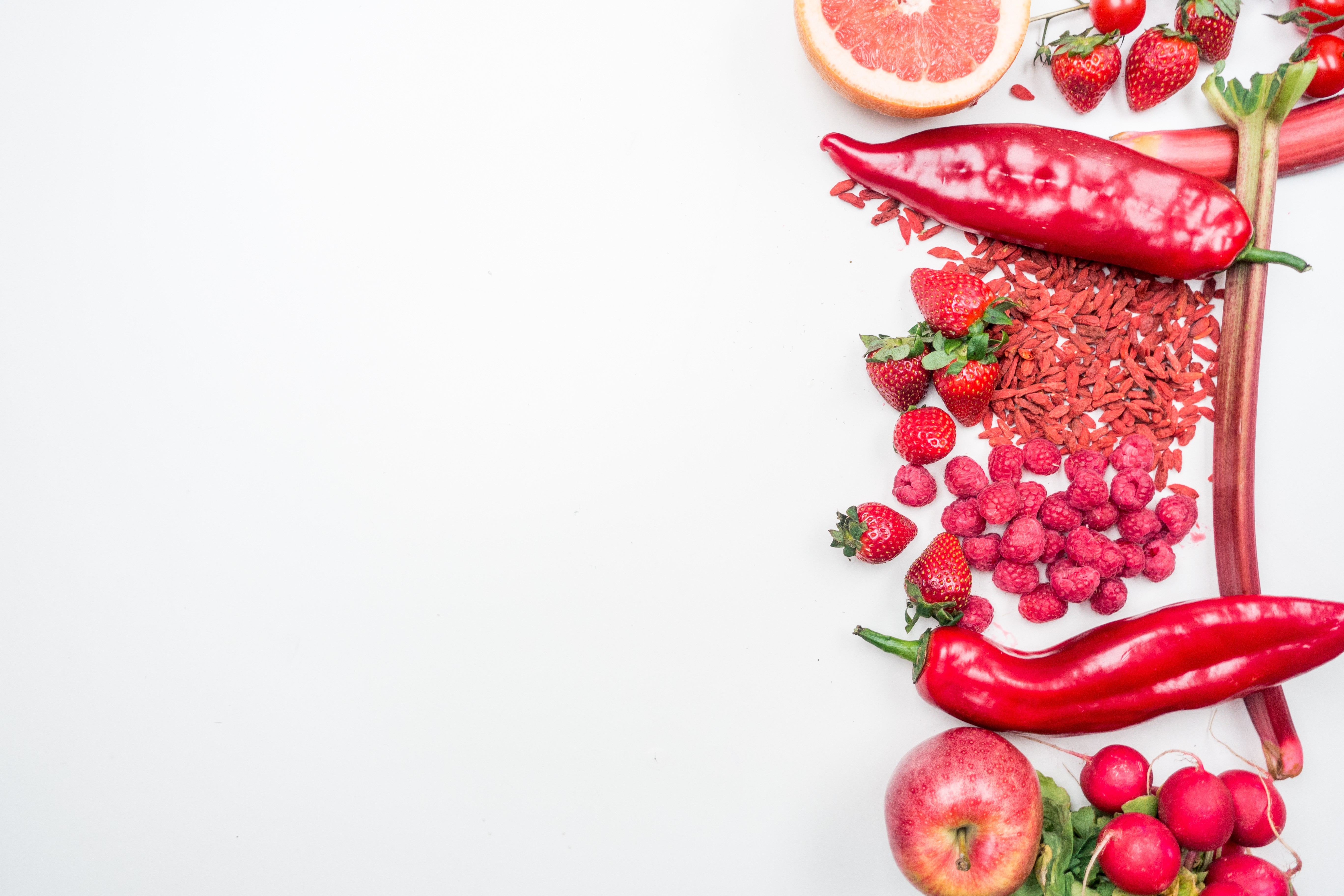 Frutas e vegetais vermelhos sobre um fundo branco