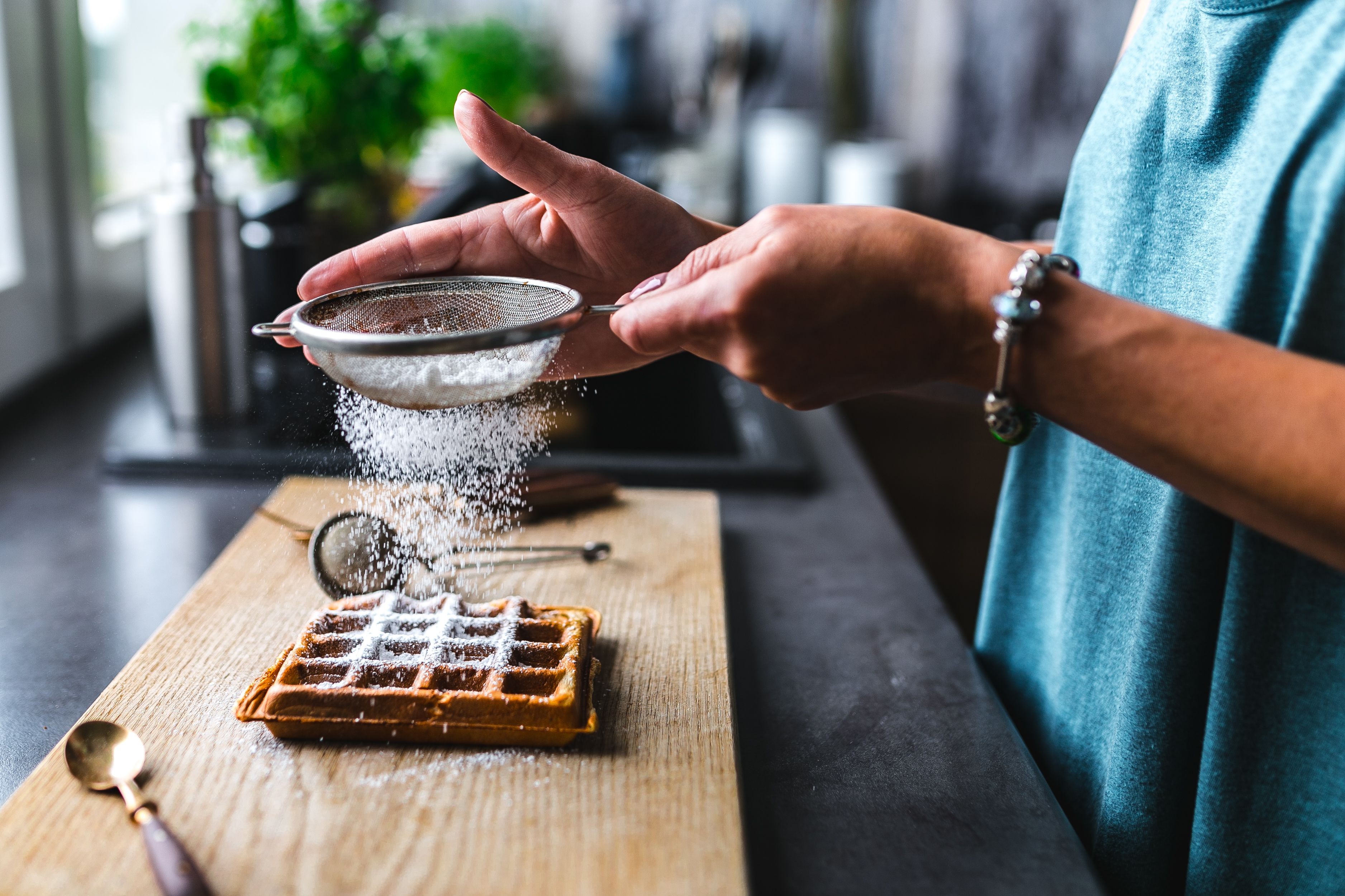 Woman pouring sugar over her waffle