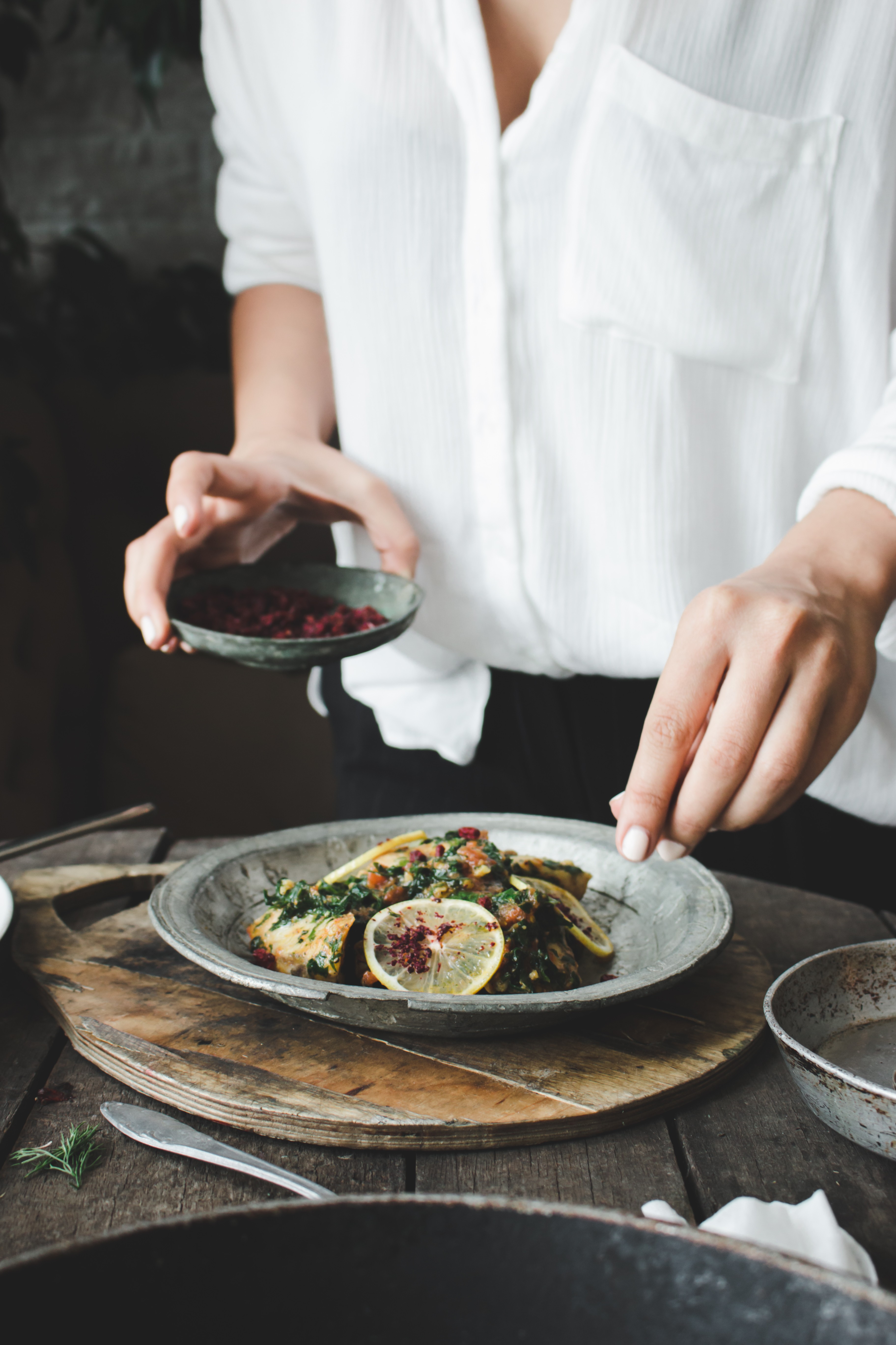 Woman seasoning her meal with hot spice