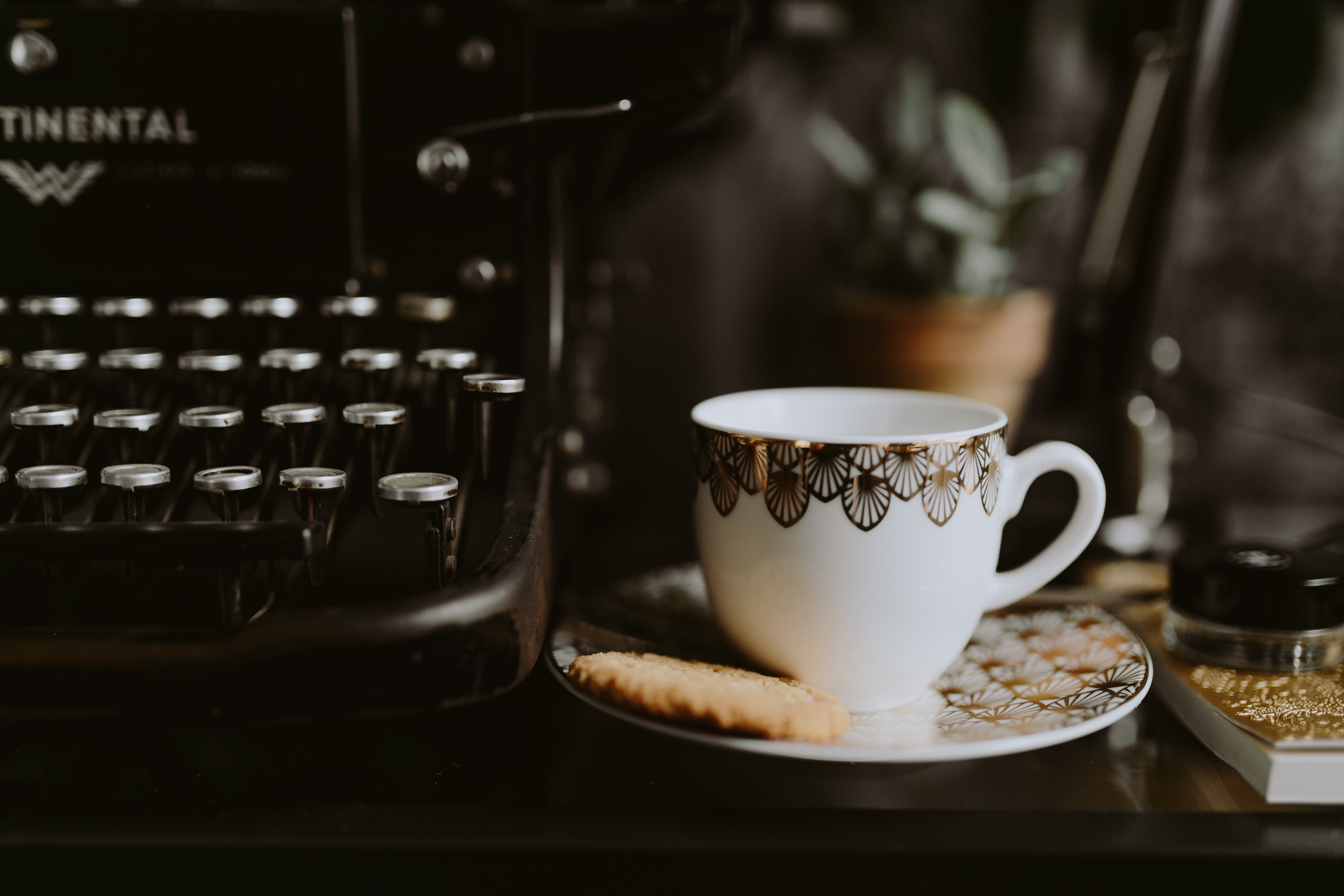 Escrevendo em uma máquina de escrever com café e biscoito